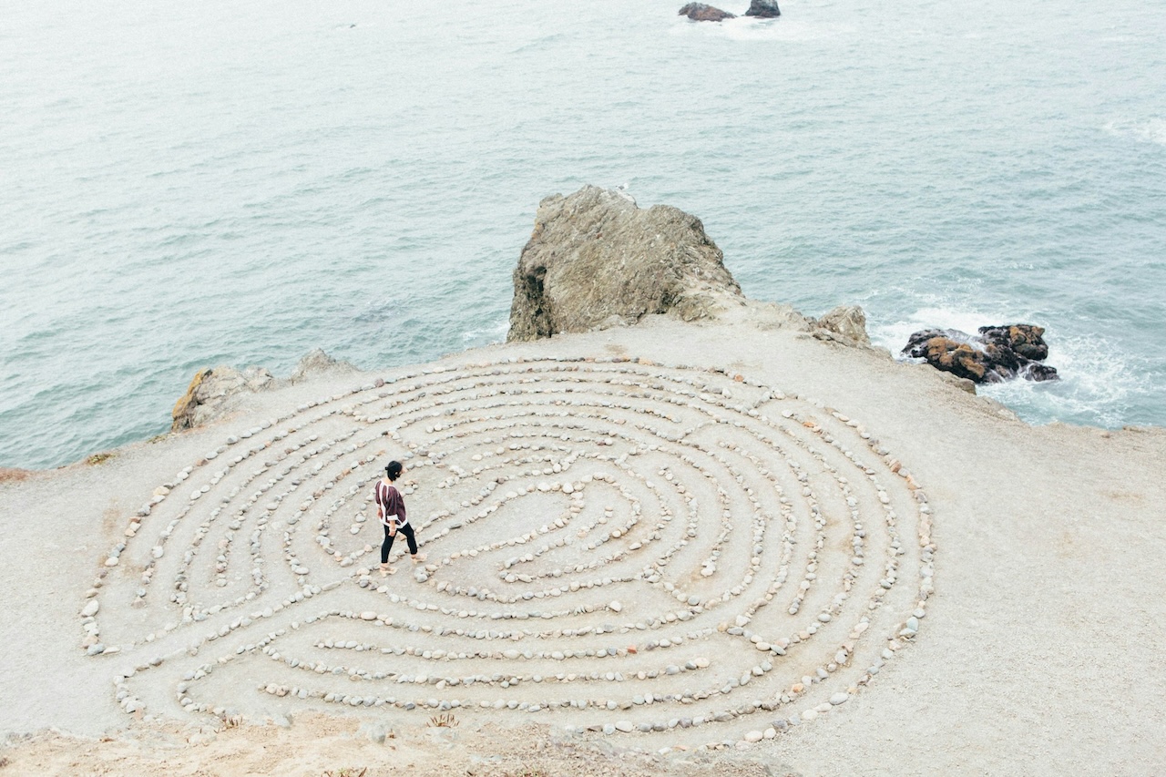 Person walking through a maze created with shells on a beach