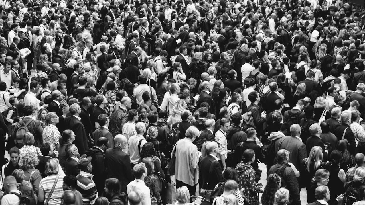 Large amount of people walking into an office building together