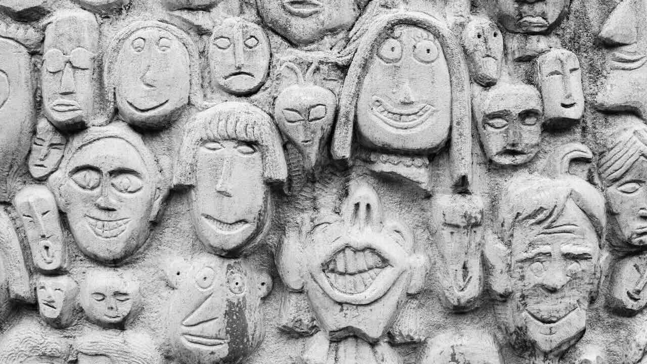 Various faces carved out of a concrete wall
