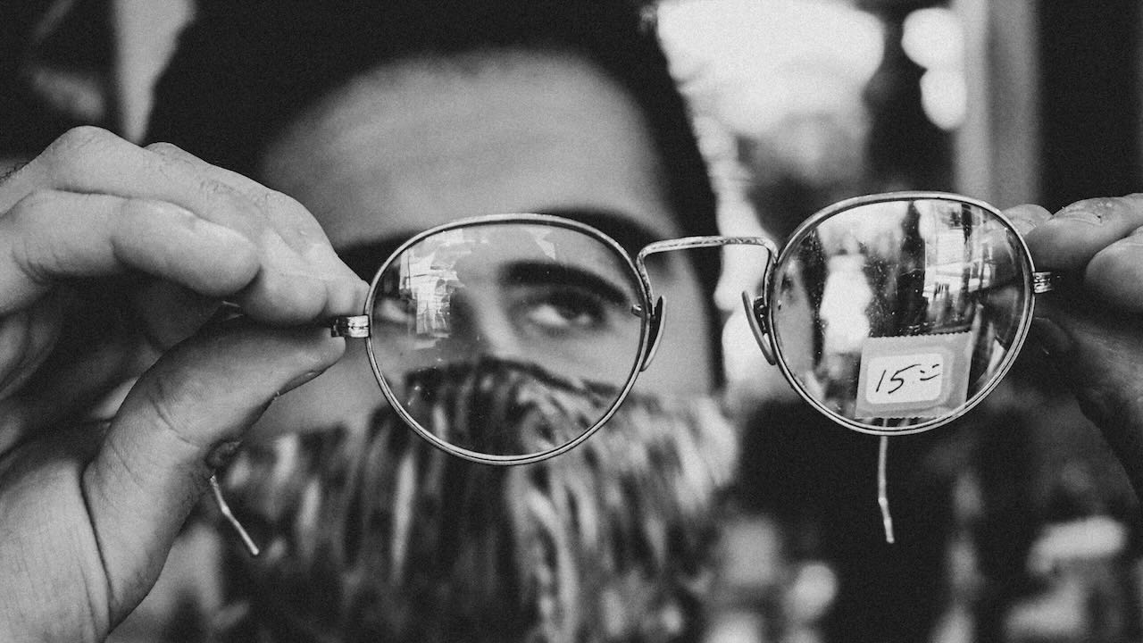 Man looking through glasses to ensure he is looking at the right things